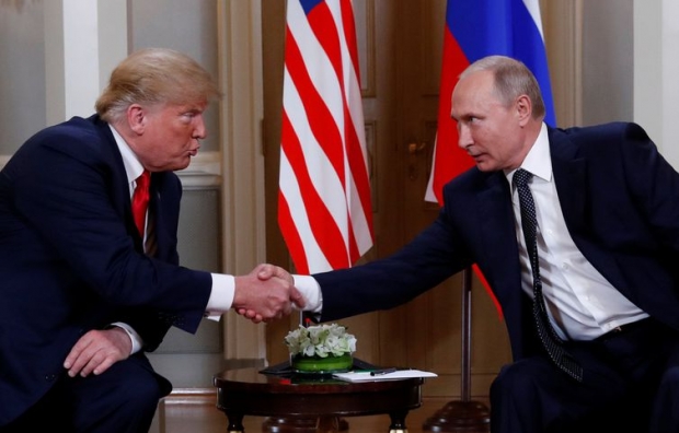 U.S. President Donald Trump and Russia's President Vladimir Putin react as they shake hands during their meeting in Helsinki, Finland July 16, 2018. REUTERS/Kevin Lamarque