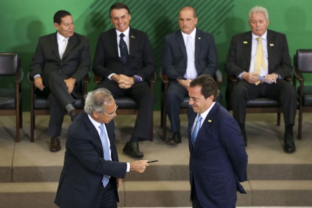 O ministro da Economia Paulo Guedes, assina o termo de posse do presidente da Caixa, Pedro Guimarães, durante cerimônia de posse aos presidentes dos bancos públicos. 