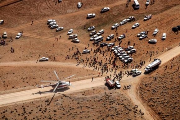 Helicópteros e carros se aproximam do lugar do acidente com dezenas de pessoas para fazer o resgate