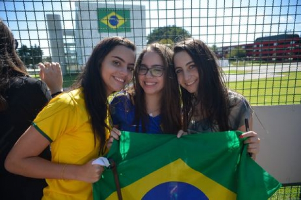 Torcedores fazem festa na porta do hotel onde a Seleção Brasileira está hospedada. Na foto, Giulia Estevão e as irmãs Julia e Luiza Vasconcelos eram as mais animadas no local (Fabio Rodrigues Pozzebom/Agência Brasil)