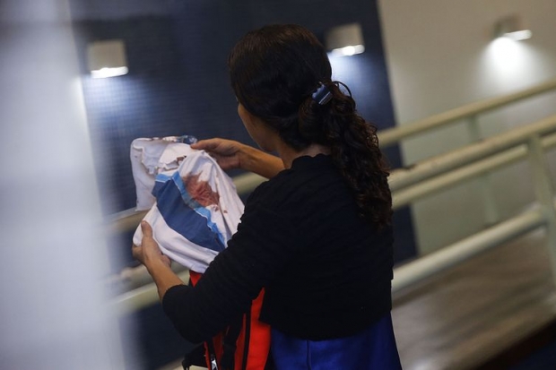 Bruna, mãe do adolescente Marcos Vinicius da Silva, de 14 anos, atingido por uma bala perdida durante operação na favela da Maré, segura camisa da escola que o estudante usava. 