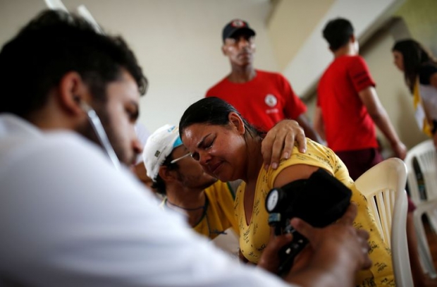 Uma mulher recebe atendimento médico depois que uma represa, de propriedade da mineradora brasileira Vale SA, explodiu em BrumadinhoUma mulher recebe atendimento médico depois que uma barragem, de propriedade da mineradora brasileira Vale SA,