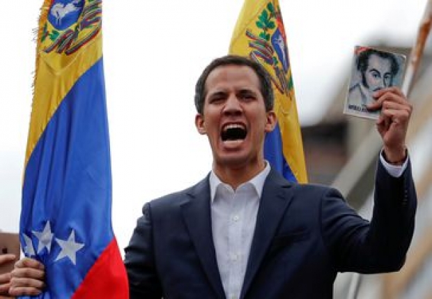 Juan Guaido, President of Venezuela's National Assembly, holds a copy of Venezuelan constitution during a rally against Venezuelan President Nicolas Maduro's government and to commemorate the 61st anniversary of the end of the dictatorship of