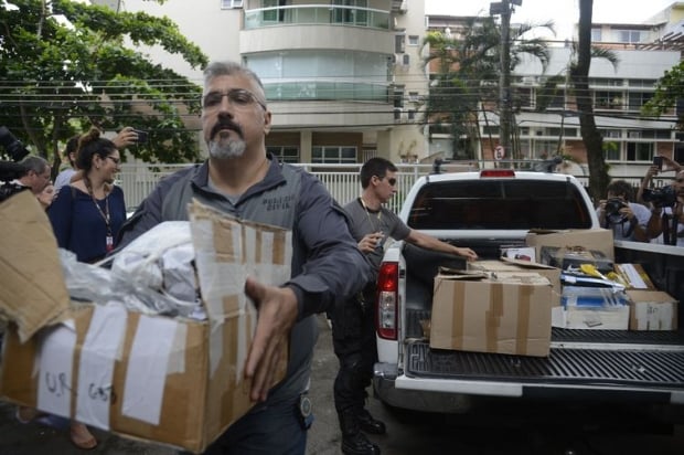 Policiais carregam caixas apreendidas em endereço ligado a suspeito de matar a vereadora Marielle Franco e o motorista Anderson Gomes em 14 de março de 2018.