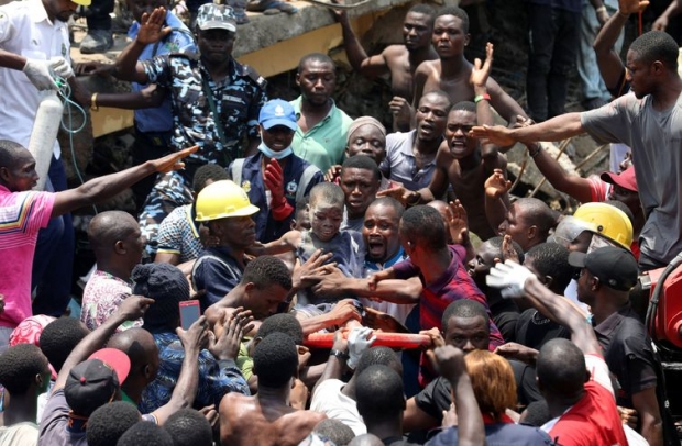Temilade Adelaja/Reuters/Direitos Reservados Men carry a boy who was rescued at the site of a collapsed building containing a school in Nigeria's commercial capital of Lagos, Nigeria March 13, 2019. REUTERS/Temilade Adelaja