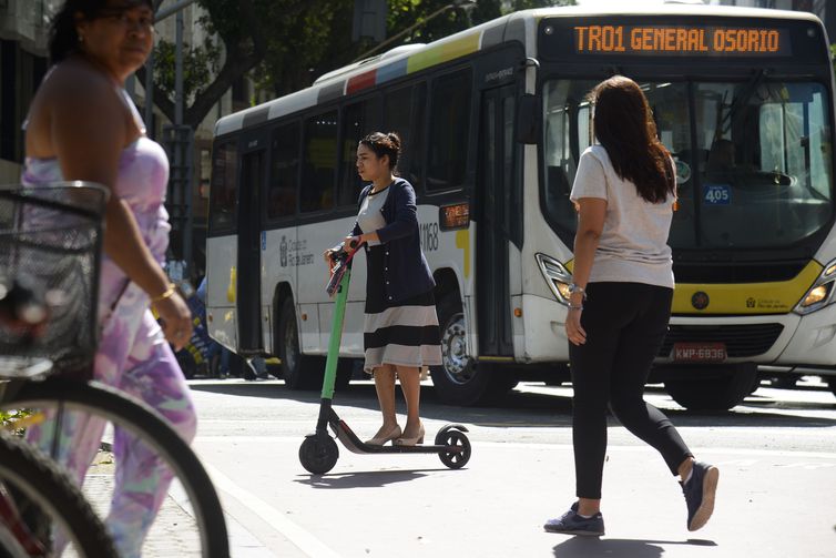 A atuária Samara Alce se locomove de patinete elétrico no centro do Rio de Janeiro.