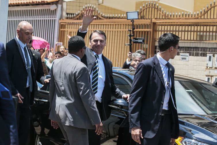 O presidente Jair Bolsonaro acena para populares durante visita a Ceilândia