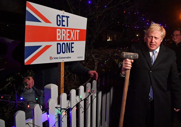Britain's Prime Minister and Conservative party leader Boris Johnson poses with a sledgehammer, after hammering a "Get Brexit Done" sign into the garden of a supporter, in South Benfleet, Britain December 11, 2019. Ben Stansall/Pool via REUTERS