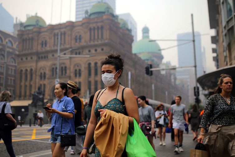 Pedestrians are seen wearing masks as smoke haze from bushfires in New South Wales blankets the CBD in Sydney, Australia, December 10, 2019. AAP Image/Steven Saphore/via REUTERS ATTENTION EDITORS - THIS IMAGE WAS PROVIDED BY A THIRD PARTY. NO