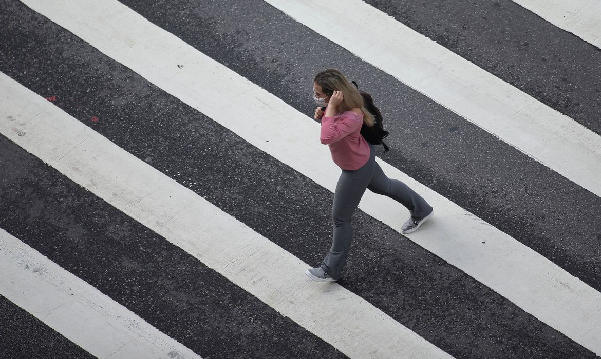 REUTERS/Rahel Patrasso/Direitos reservados Mulher com máscara de proteção em avenida de São Paulo