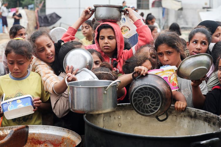 Ramadan Abed Palestinos aguardam para receber comida preparada por uma cozinha comunitária, em Nuseirat, Faixa de Gaza
08/04/2025
REUTERS/Ramadan Abed